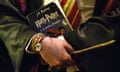 A Harry Potter fan holds a wand and a copy of Harry Potter and the Philosopher’s Stone at a 20th anniversary event in Uruguay.