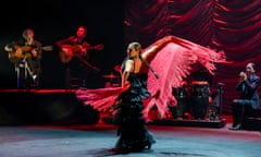 Sara Baras, in sleeveless black dress, swishing a red shawl in dramatic fashion