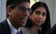 Suella Braverman looks on as Rishi Sunak (in the foreground, blurred) speaks