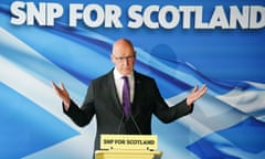 John Swinney stands at a lectern