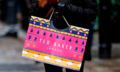 A customer carries a Ted Baker-branded shopping bag