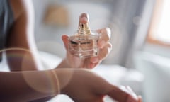 Posed by model African American woman spraying perfume on wrist