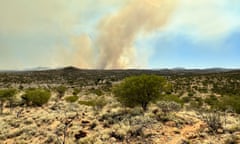 Scrubland north of Alice Springs with columns of smoke rising in the distance