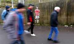 fans walk past graffiti featuring Stoke City's Ryan Shawcross
