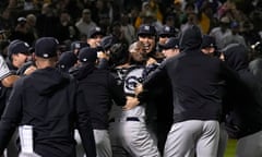 Yankees pitcher Domingo Germán is mobbed by his team-mates after throwing a perfect game on Wednesday night against the Athletics at Oakland Coliseum.