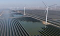 Wind turbines dot the coastline along a giant solar farm near Weifang in eastern China's Shandong province