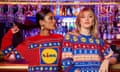 Two women wear Christmas jumpers featuring the Lidl logo