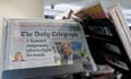 Copies of the Daily Telegraph on a rack in a supermarket