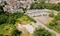 Aerial view of derelict factories and grassland bordering a residential area