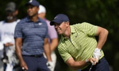 Rory McIlroy watches his tee shot on the 17th with playing partners Tiger Woods and Jordan Spieth in the background.