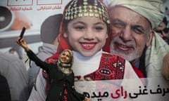 A member of Ashraf Ghani’s election campaign team takes a selfie next to a poster of him during a post-poll party in Kabul, Afghanistan.