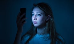 A young woman using an smart phone looking