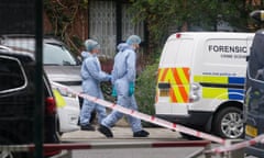 Forensic officers in white suits nears crime scene vehicles