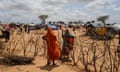 A Sudanese woman, who fled the conflict in Darfur, talks to her relative through a fence next to makeshift shelters in Chad