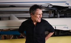 Former Olympic rower James Cracknell in front of racks of rowing boats at Crabtree Boat Club in west London
