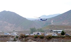 A helicopter hovers above about eight police cars near the mountains and the border of Iran and Azaerbaijian