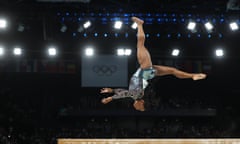 Simone Biles does an elegant somersault on the beam at the start of her Olympic comeback.