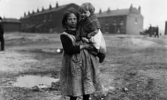 A miner's daughter carries a young child in her arms in Wigan during the coal strike of 1921.