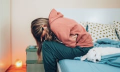 Woman with abdominal pain sitting on a bed