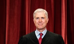 Neil Gorsuch standing against a red curtain backdrop