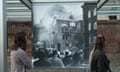 Visitors look at a photo of a synagogue burning in 1938 at a Berlin exhibition related to Kristallnacht