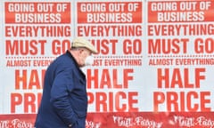 a man passes a 'going out of business' sign