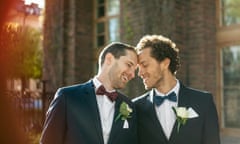 Happy newlywed gay couple standing outdoors.