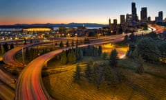 Cars drive along the Seattle Interstate 5 highway at sunset.