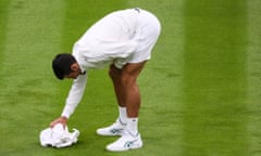 Novak Djokovic helps to dry out Centre Court last Monday.