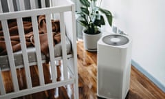 white rectangular machine, with potted plant behind it, next to a crib