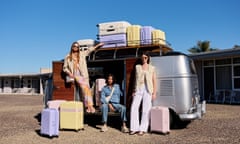 Models by a silver airstream with pastel suitcase