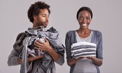 Couple holding piles of laundry