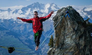 A slackliner inches across a perilously thin rope high up in the French ski resort of Les Arcs