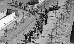 Suspected Mau Mau militants opposed to the British rule of Kenya are marched into a detention camp in 1954.