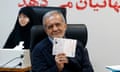 Masoud Pezeshkian holding up his passport during registration.