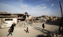 Iraqis walk along a destroyed street in the old city of Mosul eight months after the Iraqi government forces regained control from Isis.