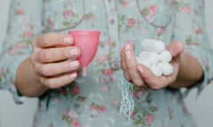 Woman holding tampons and menstrual cup in hands