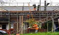 Workmen putting up scaffolding on a rooftop in Deptford, South London