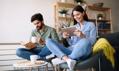 man and woman sitting on chairs reading