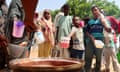 Children and women hold pots as volunteers distribute food in Omdurman, Sudan
