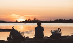 kayaks and a woman in silhouette at sunset. Kayaking and foraging trip in Sweden with Do the North.