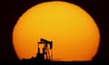 An idle oil pumping unit is silhouetted against the setting sun in a field south of Oakley, Kansas