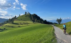 a cyclist riding towards The church of St Jacob, Bresovica, Slovenia