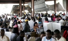 People gather to cast their votes at a polling station in a market in Port-au-Prince, Haiti