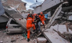 Search and rescue workers evacuate an earthquake and tsunami survivor trapped in a collapsed restaurant in Palu