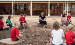 Beatrice Murray teaches students sitting on a circle of rocks in a school playground