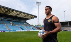 Immanuel Feyi-Waboso holds a rugby ball on Exeter's Sandy Park pitch.