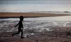 Young Aboriginal boy running on beach at Nyinykay Homeland.