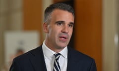 Man wearing suit and striped tie talks to the media