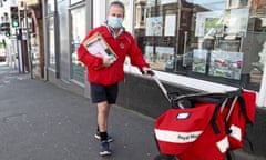 A postman wears a mask and gloves to deliver letters in Broadstairs, Kent, during the coronavirus lockdown.